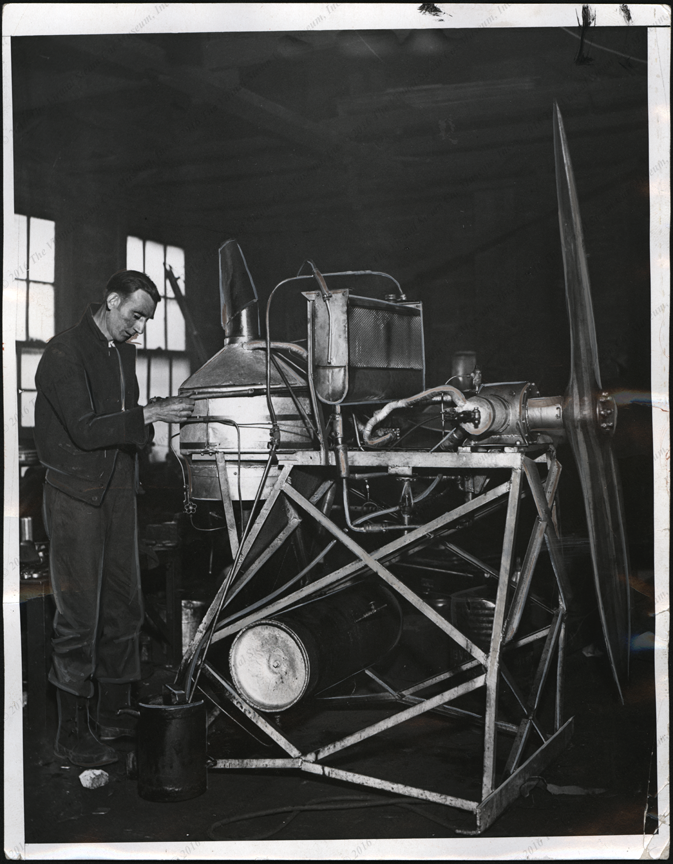 Harold C. Johnston, November 18, 1932, working on his steam areoplane engine, press photo, front
